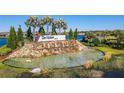 Welcoming entrance to the Del Webb community featuring a cascading waterfall, pond, and lush landscaping at 5820 Shorebird Br, Land O Lakes, FL 34638