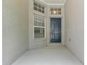 Covered entryway featuring a blue front door, windows, and neutral walls at 19713 Ellendale Dr, Land O Lakes, FL 34638