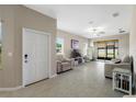 Inviting living room with neutral colors, tiled floors, and sliding door access to the backyard at 13475 Crest Lake Dr, Hudson, FL 34669