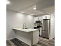 Kitchen includes white cabinets, stainless steel appliances, modern faucet and breakfast bar at 1799 N Highland Ave # 143, Clearwater, FL 33755
