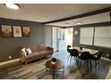 Inviting living room with modern furnishings, wood-look floors, and natural light, seamlessly connected to the dining area at 8702 El Portal Dr, Tampa, FL 33604