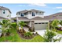 Two-story home featuring an attached garage, stone accents, and landscaping at 6018 Jensen View Ave, Apollo Beach, FL 33572