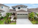 Two-story home featuring an attached garage, stone accents, and landscaping at 6018 Jensen View Ave, Apollo Beach, FL 33572