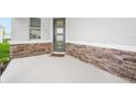 Welcoming front porch with decorative stone accents and a modern door at 6018 Jensen View Ave, Apollo Beach, FL 33572