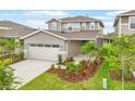 Inviting home showcasing a two-car garage, manicured lawn, and stone accents for enhanced curb appeal at 6026 Jensen View Ave, Apollo Beach, FL 33572