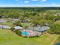 Overhead view of community amenities including a pool, tennis courts, & clubhouse amid lush greenery at 9120 Players Dr, Weeki Wachee, FL 34613
