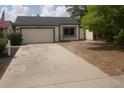 Charming single-story home with a two-car garage, wide driveway, and manicured front yard at 7314 Patio Row, Hudson, FL 34667