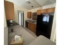 Functional kitchen featuring wood cabinets, laminate countertops, and black appliances at 2305 De Vore St, North Port, FL 34291