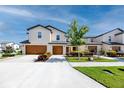 Street view of a two-story townhome showcases attached garages, green grass, and inviting landscaping at 5424 Companion Ln, Tampa, FL 33619