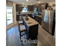 Modern kitchen with stainless steel appliances, dark cabinets, and a center island with seating at 5424 Companion Ln, Tampa, FL 33619