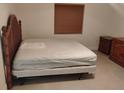 A minimalist bedroom featuring a simple bed and a dark wood dresser at 5905 Cleveland Dr, Punta Gorda, FL 33982