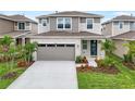Charming gray two-story home with stone accents, a gray garage door, and well-manicured landscaping at 6038 Jensen View Ave, Apollo Beach, FL 33572
