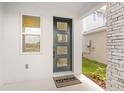 Inviting front door with modern design, sidelight window, and Richmond American Homes welcome mat at 6038 Jensen View Ave, Apollo Beach, FL 33572