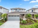 Charming two-story home features a two-car garage, well-manicured lawn, and lush landscaping at 6042 Jensen View Ave, Apollo Beach, FL 33572