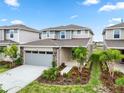 Charming two-story home features a two-car garage, well-manicured lawn, and lush landscaping at 6042 Jensen View Ave, Apollo Beach, FL 33572