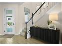 Bright foyer with modern front door, wood-look floors, staircase, and accent furniture that gives an elegant touch at 6042 Jensen View Ave, Apollo Beach, FL 33572