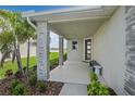 Inviting front porch with stone columns, bench seating, and verdant landscaping, offering a warm welcome at 6042 Jensen View Ave, Apollo Beach, FL 33572
