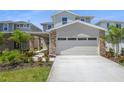 Charming two-story home with stone accents, a two-car garage, and a well-manicured lawn at 6046 Jensen View Ave, Apollo Beach, FL 33572