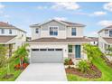 This exterior shows a two-story home featuring a two-car garage, blue front door, and vibrant landscaping at 6058 Jensen View Ave, Apollo Beach, FL 33572