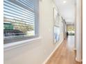 Hallway with wood floors and art leading to sliding glass doors to outdoor living area at 6058 Jensen View Ave, Apollo Beach, FL 33572