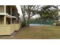 Exterior of a community tennis court showcasing greenery and trees around the fenced perimeter at 8728 Mallard Reserve Dr # 103, Tampa, FL 33614