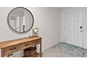 Inviting entryway with console table, round mirror, and stylish rug creating a warm and welcoming ambiance at 16750 Sunburst Lake St, Wimauma, FL 33598