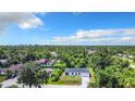 Aerial shot of the home surrounded by lush greenery and neighboring houses at 18392 Poston Ave, Port Charlotte, FL 33948
