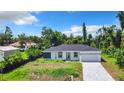 Beautiful single-story home with a two-car garage and landscaping at 18392 Poston Ave, Port Charlotte, FL 33948