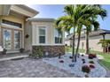 Home entrance featuring beautifully landscaped yard and decorative stone at 5497 56Th E Ct, Bradenton, FL 34203