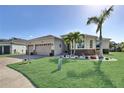 Beautiful single-story home with a well-manicured lawn, palm trees, and a two-car garage at 5497 56Th E Ct, Bradenton, FL 34203