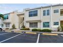 Beige condo building featuring reserved parking, stairs to upper units, and tidy landscaping at 6151 Bahia Del Mar Blvd # 125, St Petersburg, FL 33715