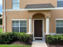 Charming townhouse entrance featuring a covered porch with columns and well-maintained landscaping at 9871 Trumpet Vine Loop, Trinity, FL 34655