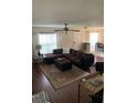 Comfortable living room with stylish brown sectional, area rug, and lots of natural light at 9871 Trumpet Vine Loop, Trinity, FL 34655