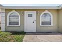 Close-up of a well-lit entryway with decorative arched windows on either side of the front door at 4408 W Prescott St, Tampa, FL 33616