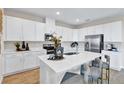 Modern kitchen featuring sleek white cabinetry, stainless steel appliances, and a quartz countertop island at 9195 Players Dr, Weeki Wachee, FL 34613