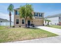 Charming two-story home featuring a green lawn, attached two-car garage, and beautifully arranged landscaping at 2746 Walden Woods Dr, Plant City, FL 33566