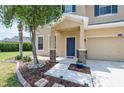 Inviting entryway with decorative stone accents, a covered porch, and lush landscaping at 2746 Walden Woods Dr, Plant City, FL 33566