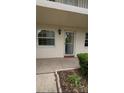 Charming condo entrance with a decorative wreath on the door and well-maintained landscaping at 870 Virginia St # 108, Dunedin, FL 34698