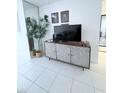 Stylish living room area featuring a patterned cabinet, greenery, and tiled flooring at 870 Virginia St # 108, Dunedin, FL 34698