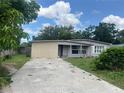 Long driveway leading to a well-kept home, surrounded by lush greenery, showing a serene outdoor space at 1009 Kenmore Dr, Brandon, FL 33510