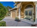 Charming home featuring an arched entryway, double doors, and an attached garage at 1103 Kensington Ct, Safety Harbor, FL 34695
