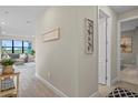 Bright hallway with wood-look tile flooring, leading to the living area and other rooms at 6288 Winding Pine Dr, Nokomis, FL 34275