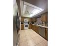 Functional kitchen featuring tile floors, wooden cabinets, and modern appliances at 12322 Alta Mira St, North Port, FL 34287