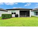 Rear exterior view of the property highlighting a screened-in lanai and well-maintained lawn at 19165 Iron Topsail Isle, Land O Lakes, FL 34638
