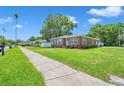 Well-maintained brick home with manicured lawn, complemented by a sidewalk and lush greenery at 2601 Upton S St, Gulfport, FL 33711