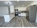 Open kitchen featuring granite countertops, stainless steel appliances, and grey wood-look tile flooring at 4546 Ontario Dr, New Port Richey, FL 34652
