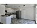 This kitchen features white cabinets, granite countertops, stainless steel appliances, and modern lighting at 4546 Ontario Dr, New Port Richey, FL 34652