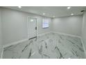 Bright and airy bedroom with marble tile floors and a white door with a window at 390 Hazel Cir, Punta Gorda, FL 33982