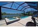 Inviting screened-in pool and spa overlooking a serene lake at 14553 Eagle Branch Dr, Nokomis, FL 34275