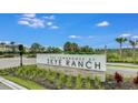 The Townhomes at Skye Ranch community sign, with lush landscaping against a bright blue sky at 8540 Daybreak St, Sarasota, FL 34241